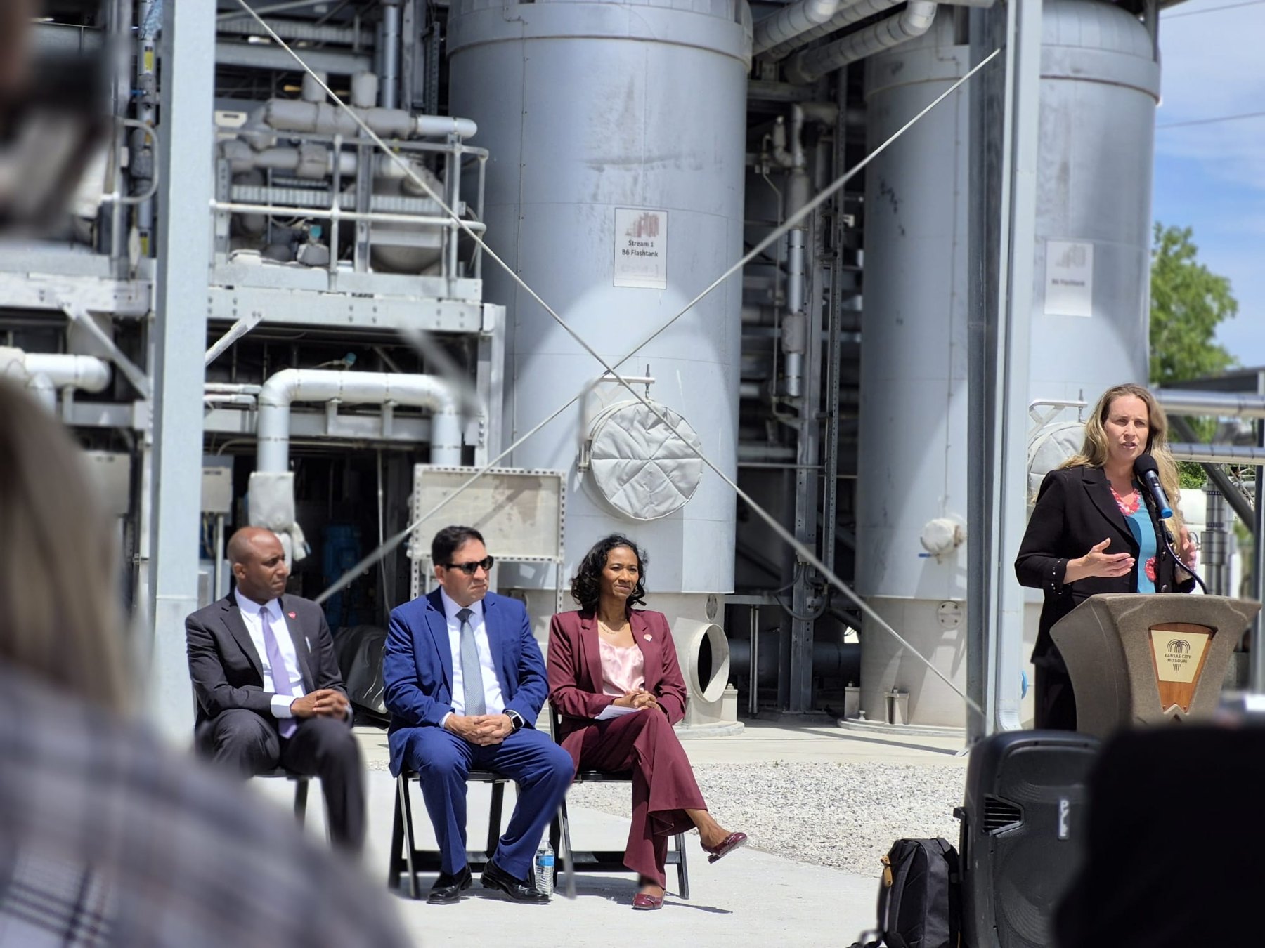 Opening ceremony speakers beside treatment facility equipment