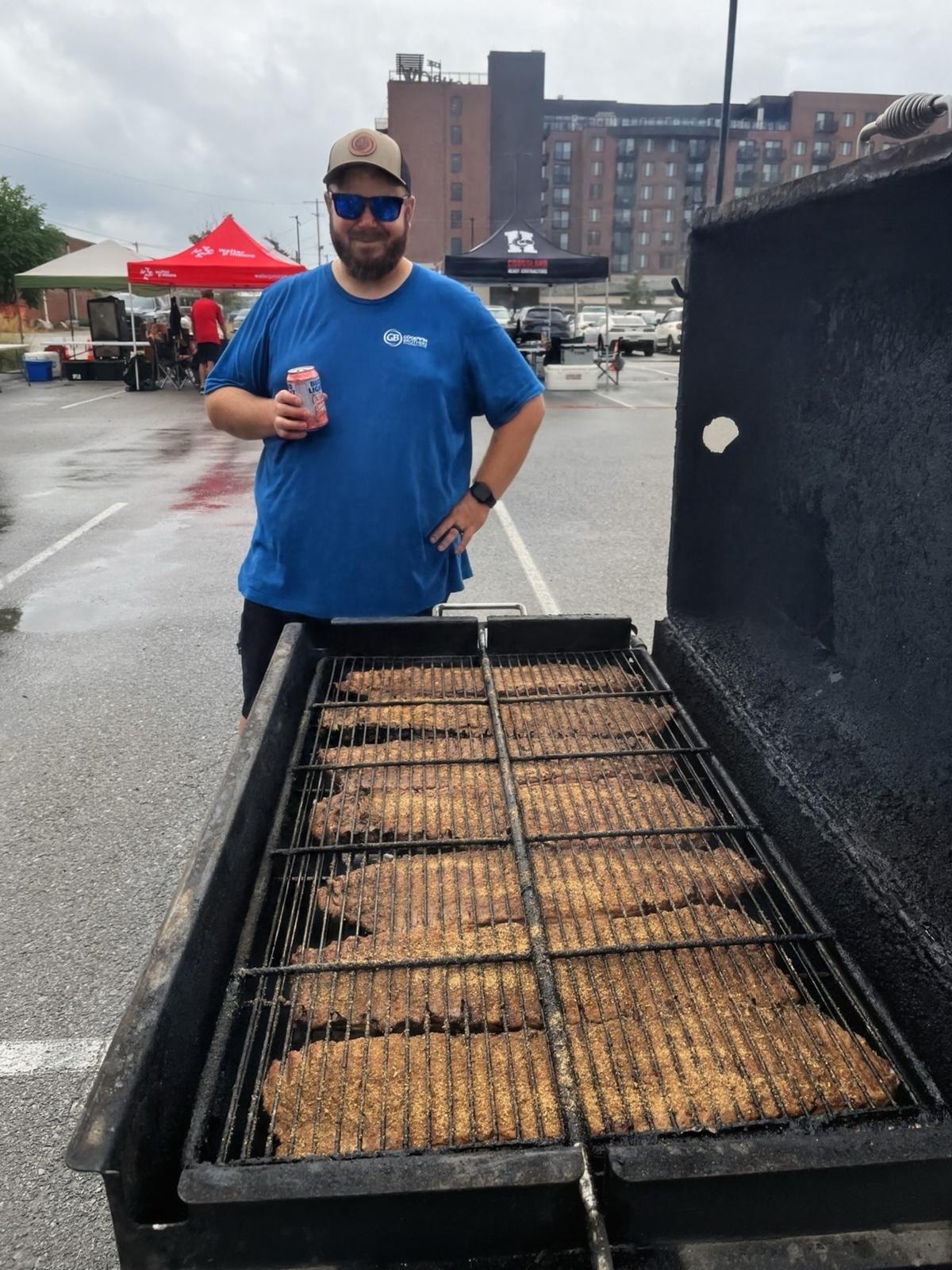 Volunteer beside an outdoor grill